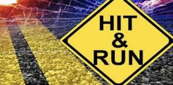 Yellow caution sign with the words "Hit & Run" stands starkly against a background of a road and shattered glass, symbolizing the chaos of a Detroit hit and run.